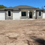 Modern Ranch-Style Home Under Construction: Stucco and Cultured Stone Elegance