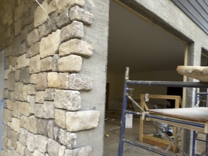 Close-up view of a newly installed cultured stone exterior, showcasing precise stone alignment and corner detailing on a residential project.