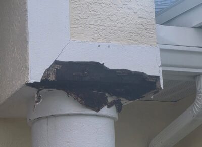 Damaged stucco around exterior column before repair